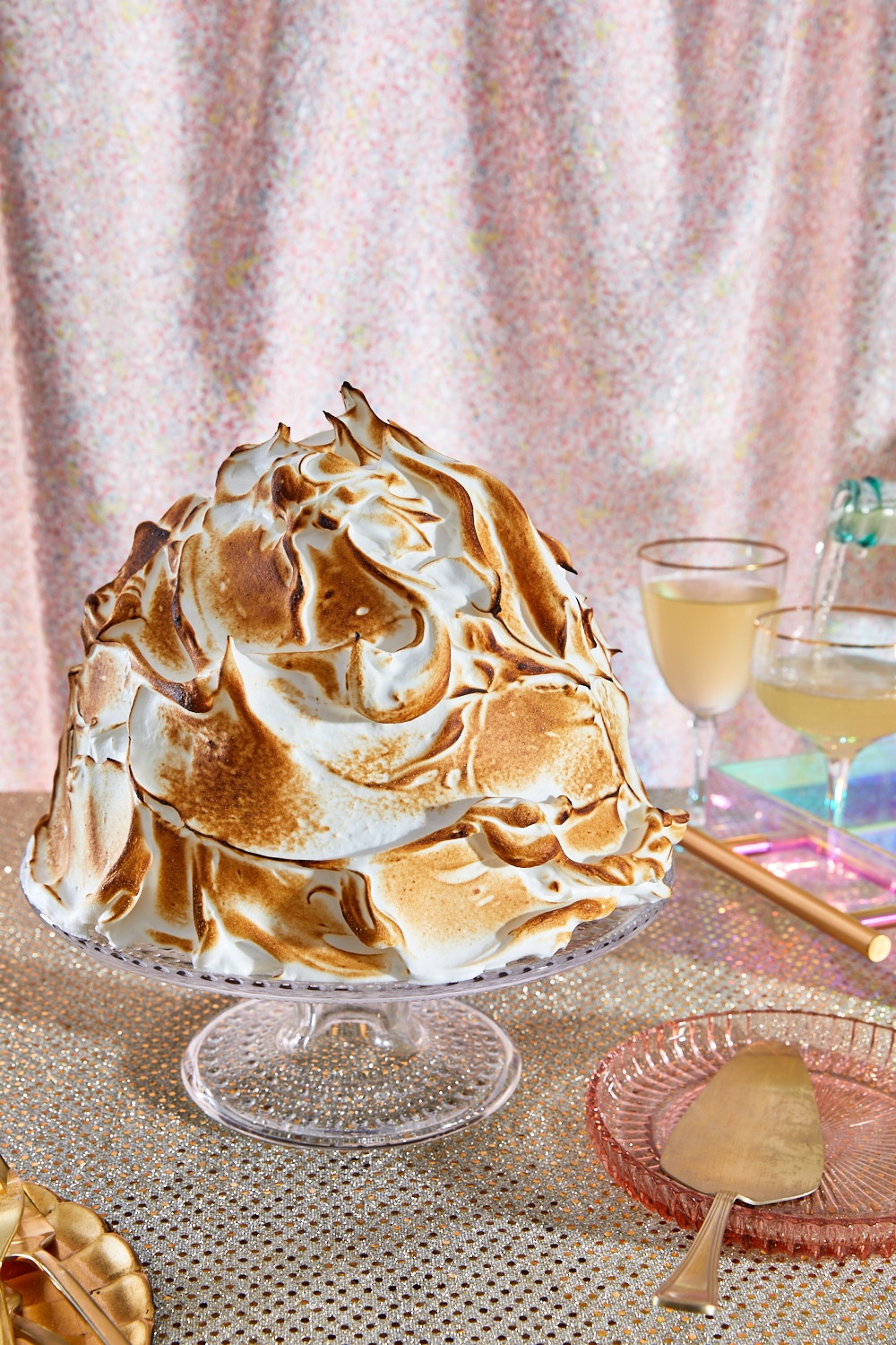 Baked Alaska with wine glasses and pink backdrop