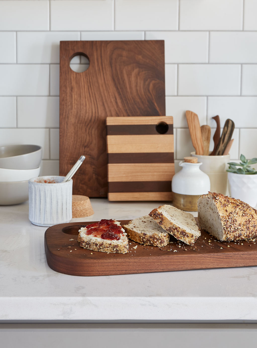 Bread and jam on a kitchen counter with tableware