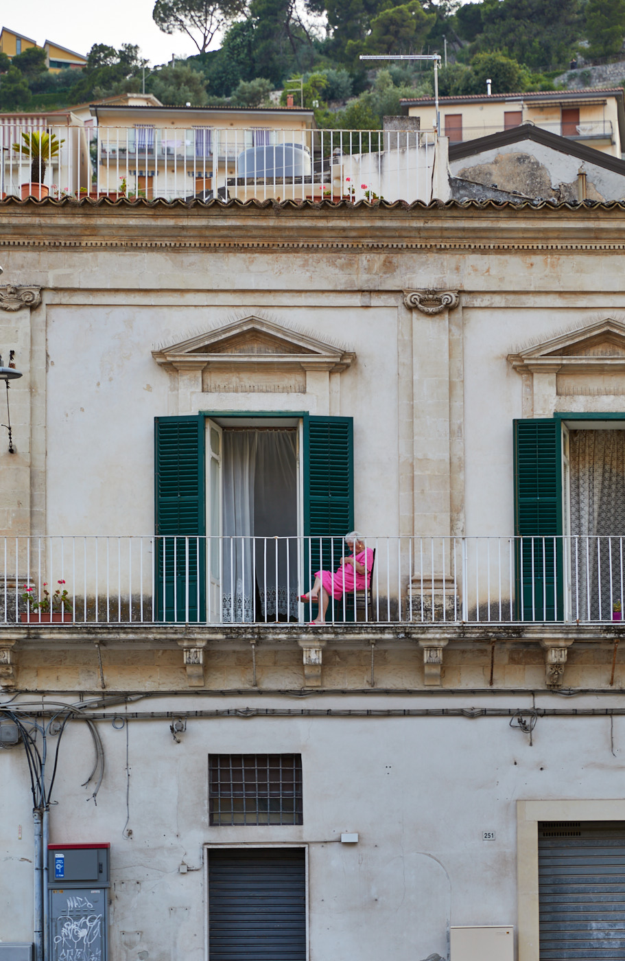 Woman in pink dress on balcony