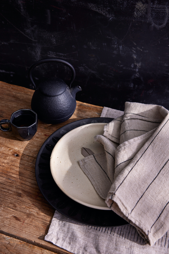 Black teapot and cup with linen